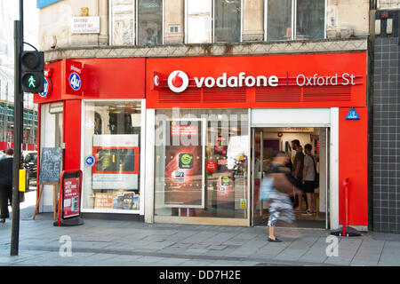 London, UK. 28. August 2013. Der Vodafone-Shop in der Oxford Street mit längere Belichtungszeit unscharf Fußgängerzone. Am 29. August startet Vodafone 4G Service für Kunden in London. Das Unternehmen investierte £ 900 Millionen im Netz. Vodafone will roll-out der Service für 12 weitere Städte einschließlich Sheffield, Leeds und Manchester vor Ende 2013. Kunden auf einer SIM-Karte nur 12-Monats-Vertrag werden voraussichtlich £26 pro Monat, £5 mehr als die durchschnittliche 3G-Dienst zu zahlen. Bildnachweis: Pete Maclaine/Alamy Live-Nachrichten Stockfoto