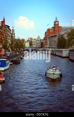 Belebten Stadtzentrum von Amsterdam und den berühmten Grachten, die durch die einheimische und Touristen eine Fahrt entlang der legendären Route nehmen. Stockfoto