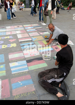 Street Art Künstler Skizzieren verschiedene Nationalflaggen auf dem Boden am Trafalgar Square in London Stockfoto