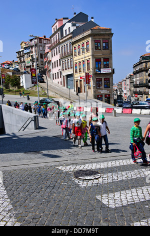 Portugiesische Schulkinder auf einem Ausflug mit ihren Lehrern, mit farbigen Kappen außerhalb der Bahn Bahnhof, Porto, Porto, Portugal Stockfoto