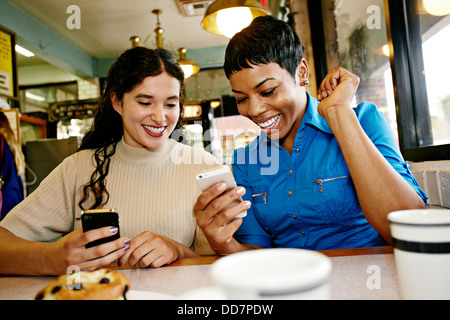 Frauen, die Nutzung von Mobiltelefonen im restaurant Stockfoto