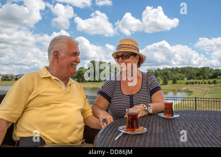 Senior paar mit türkischen Tee in ihre Pattio während ihrer Hände und sahen einander glücklich Stockfoto