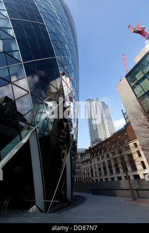 30 St Mary Axe, der Schweizer Rück-Gebäude (bekannt als die Gurke) mit Heron-Tower im Hintergrund, London, England, UK. Stockfoto