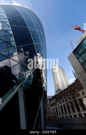 30 St Mary Axe, der Schweizer Rück-Gebäude (bekannt als die Gurke) mit Heron-Tower im Hintergrund, London, England, UK. Stockfoto