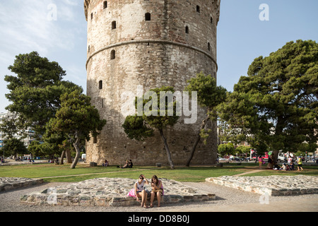 Zwei Mädchen entspannen unter den weißen Turm (Lefkos Pyrgos) in Thessaloniki, Griechenland. Stockfoto