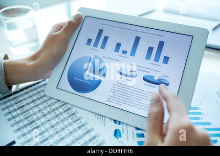 Nahaufnahme von einem finanziellen Analysator hält eine digitale Tafel mit statistischen Daten Stockfoto