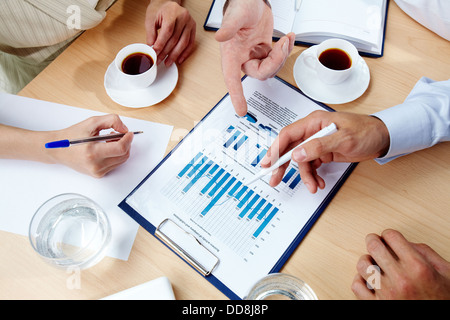 Bild von Menschenhand mit Stiften über Geschäftsdokument Tagung Stockfoto