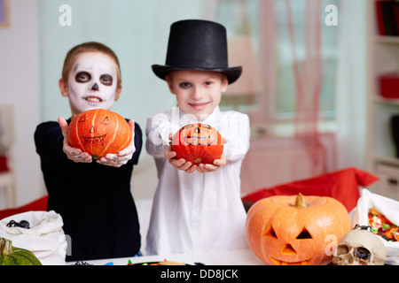 Foto von zwei unheimlichen jungen zeigen Halloween Kürbisse Stockfoto