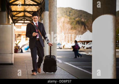 Hispano-Amerikaner Geschäftsmann rollenden Gepäck Stockfoto