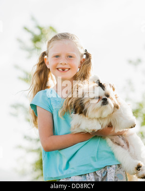 Kaukasische Mädchen halten Hund im freien Stockfoto