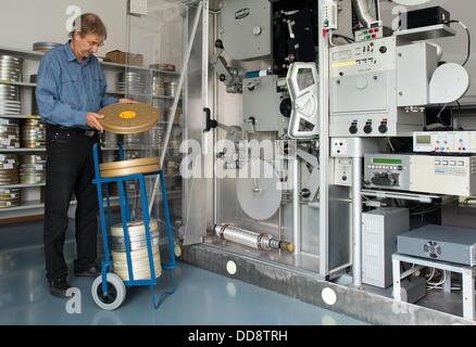 Der Direktor der Abteilung für Restaurierung und Konservierung, Egbert Koppe, Film Film-Dosen in einem Lagerraum bei German Federal Film Archive in Hoppegarten, Deutschland, 12. August 2013. Koppe ist besorgt über den desolaten Zustand von einigen Film-Depots, die auf verschiedene Einrichtungen an verschiedenen Orten verteilt sind. Gespräche gehen seit Jahren in Bezug auf eine neue zentrale Einrichtung für Film Konservierung und Archivierung in Hoppegarten bei Berlin. Foto: Patrick Pleul Stockfoto