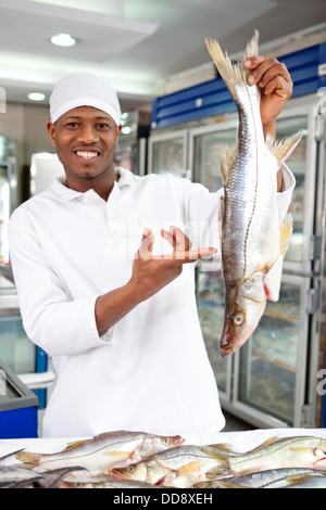 Gemischte Rassen Lebensmittelhändler Zubereitung von Fisch im Markt Stockfoto