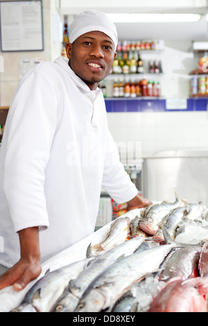 Gemischte Rassen Lebensmittelhändler Zubereitung von Fisch im Markt Stockfoto