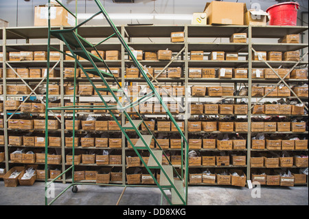 Rollende Treppe von Regalen in Textilfabrik Stockfoto