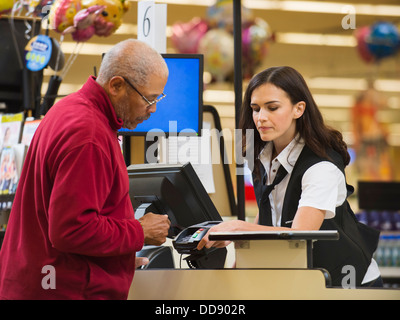 Kassierer und Kunden an der Supermarkt-Kasse Stockfoto