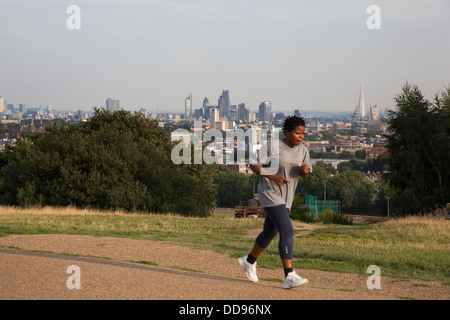 Läufer auf Parlament-Hügel mit einem erstaunlichen Blick auf die City of London von Hampstead Heath, London, UK. Stockfoto