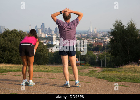 Läufer auf Parlament-Hügel mit einem erstaunlichen Blick auf die City of London von Hampstead Heath, London, UK. Stockfoto