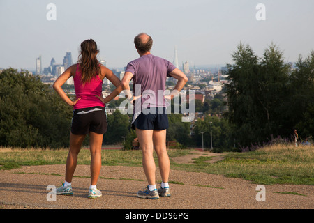 Läufer auf Parlament-Hügel mit einem erstaunlichen Blick auf die City of London von Hampstead Heath, London, UK. Stockfoto