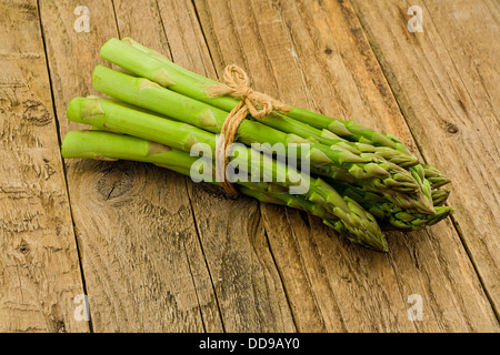 Spargel Bund ein Premium-Saisongemüse auf eine ländliche rustikale antiken hölzernen Tischplatte-Einstellung Stockfoto