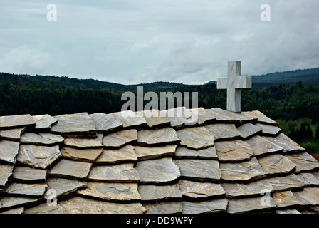 Das Dach der alten Kirche gedeckt mit Steinplatten und einen stürmischen Himmel im Hintergrund. Stockfoto