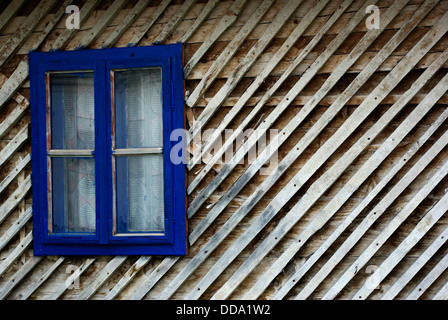 Blauen Fensterrahmen auf die alte Holzhütte. Stockfoto