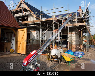 Hausbau, Bau Dach, Verwendung von Bumpa Aufzug, Bündel von Fliesen zu oberen Gerüste zu erhöhen Stockfoto