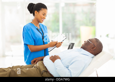 schöne afrikanische Ärztin Beratung senior Patienten im Büro Stockfoto