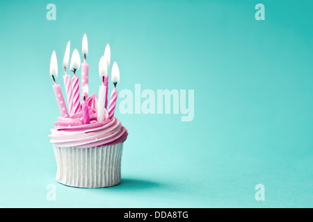 Cupcake mit rosa Geburtstagskerzen geschmückt Stockfoto