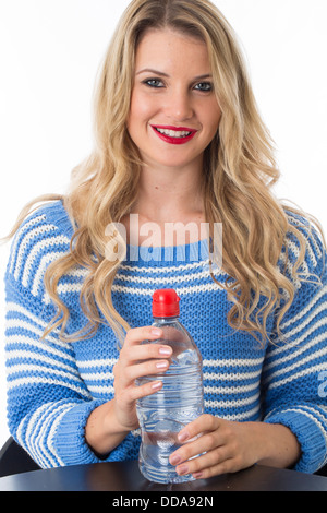 Gesund selbstbewussten jungen Frau mit einem Kunststoff Flasche noch frisch erfrischenden Trinkwasser Isoliert gegen einen weißen Hintergrund mit einen Freistellungspfad Stockfoto