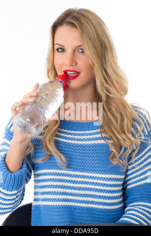 Gesund selbstbewussten jungen Frau mit einem Kunststoff Flasche noch frisch erfrischenden Trinkwasser Isoliert gegen einen weißen Hintergrund mit einen Freistellungspfad Stockfoto