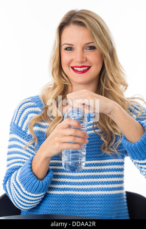 Gesund selbstbewussten jungen Frau mit einem Kunststoff Flasche noch frisch erfrischenden Trinkwasser Isoliert gegen einen weißen Hintergrund mit einen Freistellungspfad Stockfoto