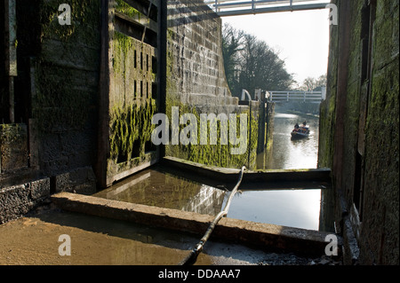 Blick von durchlässigen Schleusenkammer durch offene Tore zu Kanal Boot - Fünf Aufstieg Schlösser für Renovierungsarbeiten geschlossen, Leeds Liverpool Canal, Bingley, England, Großbritannien Stockfoto
