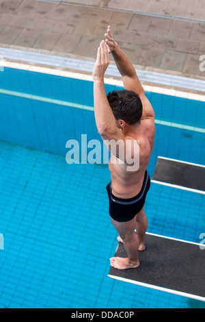 Mann bereit, springen vom Sprungbrett im Schwimmbad Stockfoto