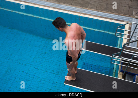 Menschen mit Angst vor der Höhe stehend auf Sprungbrett im Schwimmbad über dem Wasser Stockfoto
