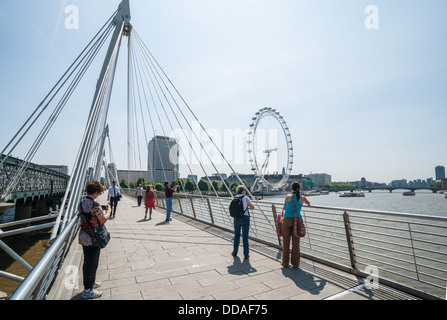 Touristen auf der Jubilee Bridge in London im Juli 2013. Auch Knon als Hungerford Bridge. Stockfoto