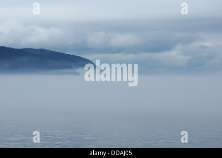 Dichter Nebel über dem Wasser mit Berge und Wolken, Landschaft toll. Stockfoto