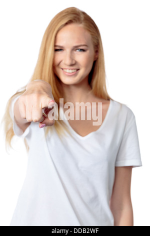 Junge Frau lächelt und auf den Betrachter mit dem Zeigefinger zeigt, wie sie eine Wahl macht oder eine Person mit Fokus auf ihr Gesicht, isoliert auf weiss identifiziert Stockfoto
