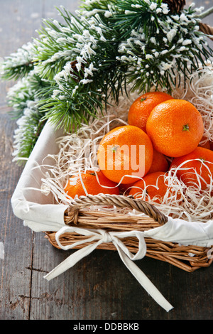 Mandarinen im Korb mit Weihnachtsbaum Zweig Stockfoto