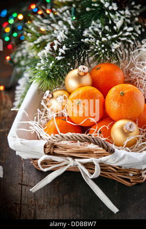 Mandarinen im Korb mit Weihnachtsbaum Zweig Stockfoto