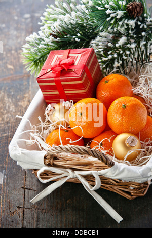 Mandarinen in Korb mit Geschenk und Weihnachtsbaum Zweig Stockfoto