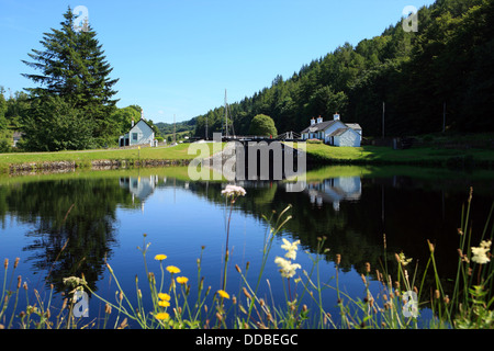 Schleusenwärter Hütten spiegelt sich in einer noch Crinan Canal an der Dunardry Brücke in Argyll, Schottland Stockfoto