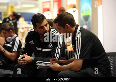 Cardiff, UK. Mittwoch, 28. August 2013 im Bild L-r: Jordi Amat Interview mit Chris Barney am Cardiff Airport.  Re: Swansea City FC Spielern und Mitarbeitern unterwegs für die UEFA Europa League ausspielen Runde, 2. Etappe, gegen Petrolul Ploiesti in Rumänien. © D Legakis/Alamy Live-Nachrichten Stockfoto