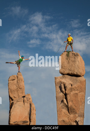 Team von männlichen Bergsteigern erobern die Gipfel von einem anspruchsvollen Rock-Turm. Stockfoto