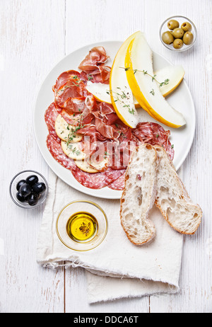 Platte mit verschiedenen Wurstwaren und Melone Stockfoto