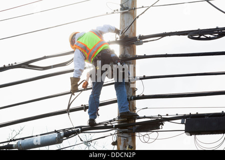 Kommunikation Arbeiter auf einem Strommast Sicherheitsgurt Gurt wird vorbereitet, Kabel zu unterstützen Stockfoto