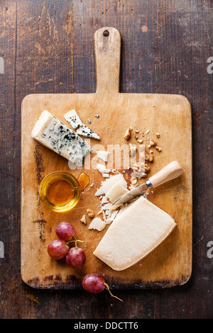 Käse mit Honig, Nüssen und Trauben auf hölzernen Cutting Board Stockfoto