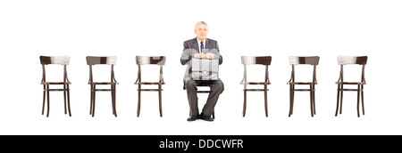 Reife Geschäftsmann im Anzug eine Aktentasche aus Leder halten und warten auf Job-Interview auf einem Stuhl Stockfoto