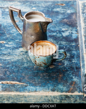 Tasse Kaffee mit Milch auf blauem Hintergrund Stockfoto