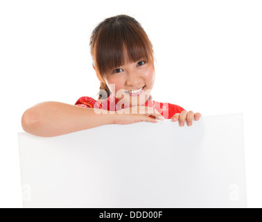 Asiatin mit chinesischen traditionellen Kleid Cheongsam oder Qipao, leeres weißes Papierkarte halten. Chinesisches Neujahr-Konzept, weibliches Modell isoliert auf weißem Hintergrund. Stockfoto