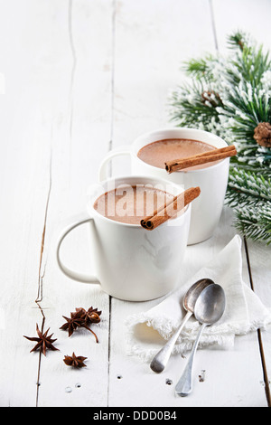 Heißer Kakao mit Zimtstangen auf weißem Holz Hintergrund Stockfoto